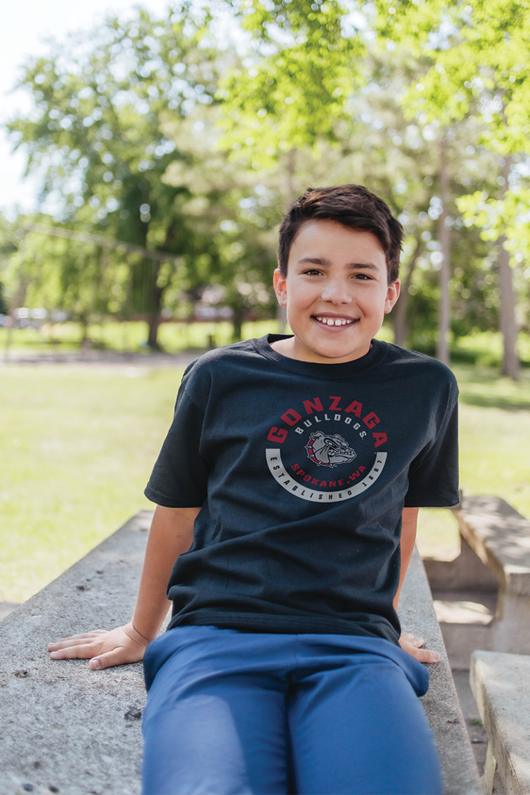 Youth model wearing a college Blue 84 t-shirt.